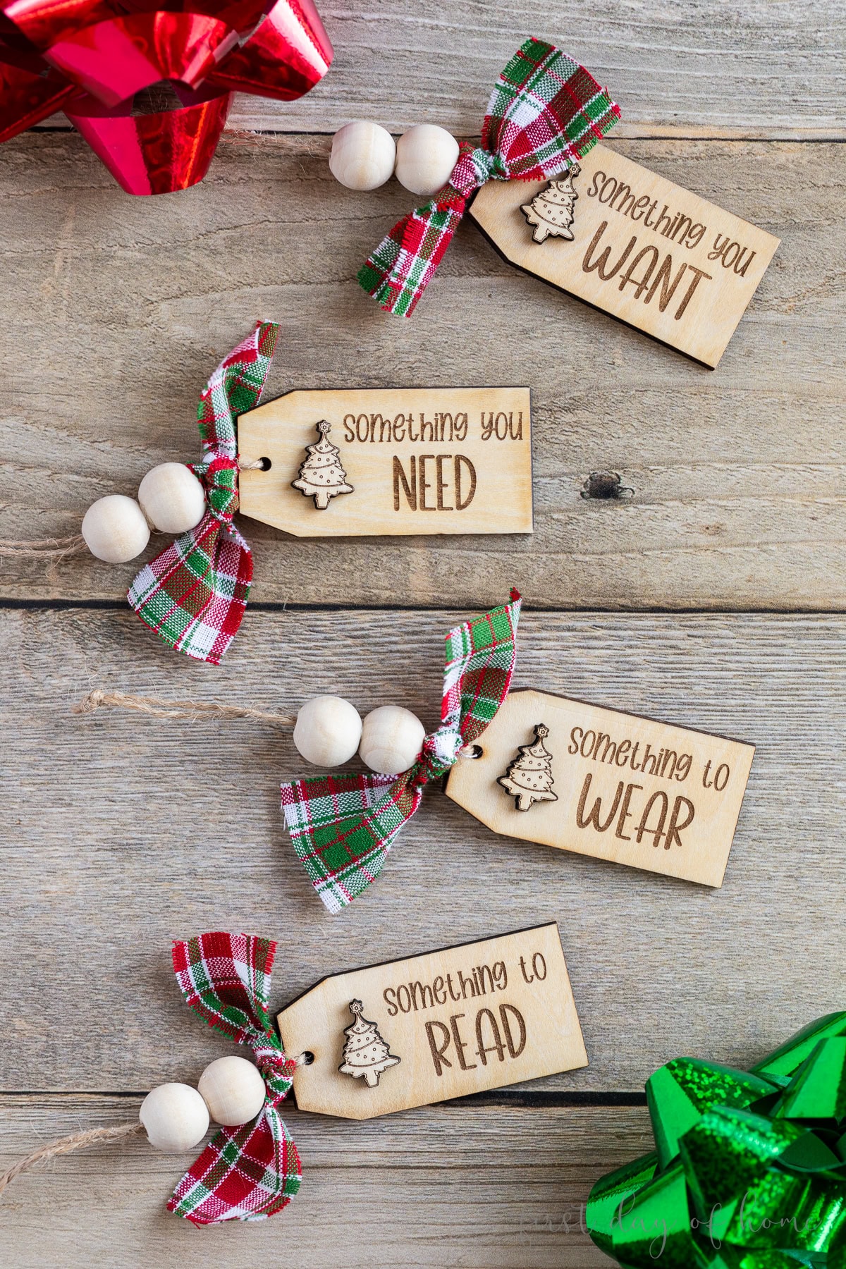 Four laser engraved Christmas gift tags that read "Something to wear, something to read, something you want, and something you need."