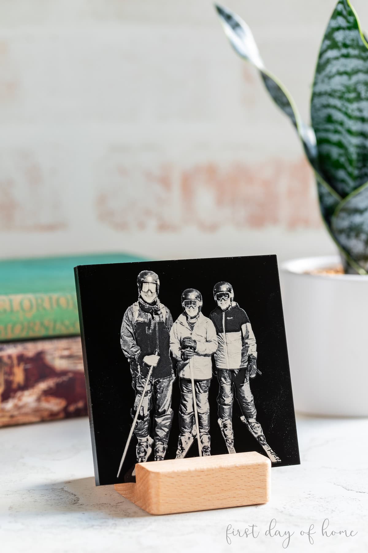 Laser engraved black acrylic tile with photo of three people in ski clothes.
