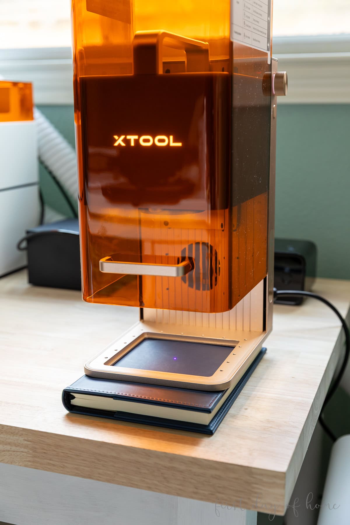 Leatherette notebook placed under an xTool F2 machine for laser engraving.