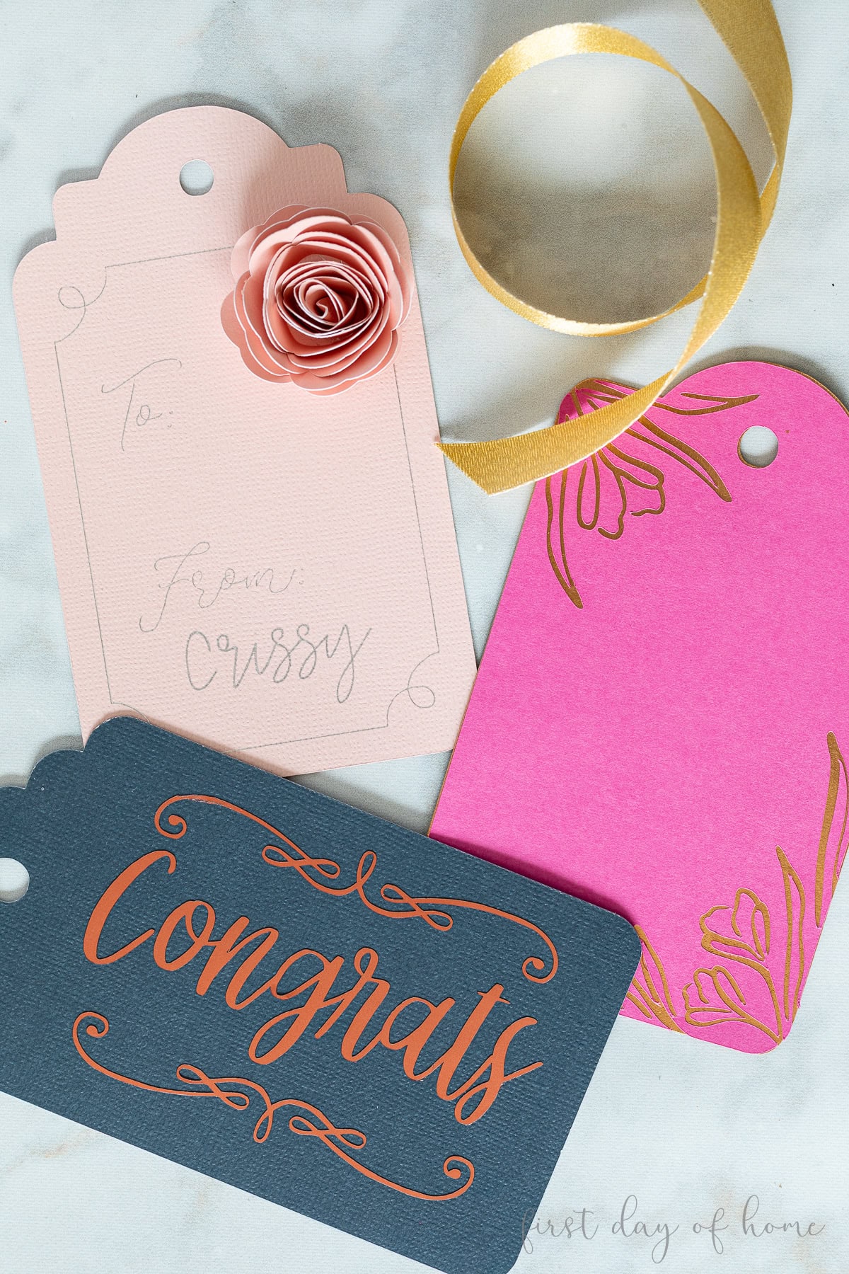 Three Cricut gift tags with a vinyl phrase, layered design, and paper flower.