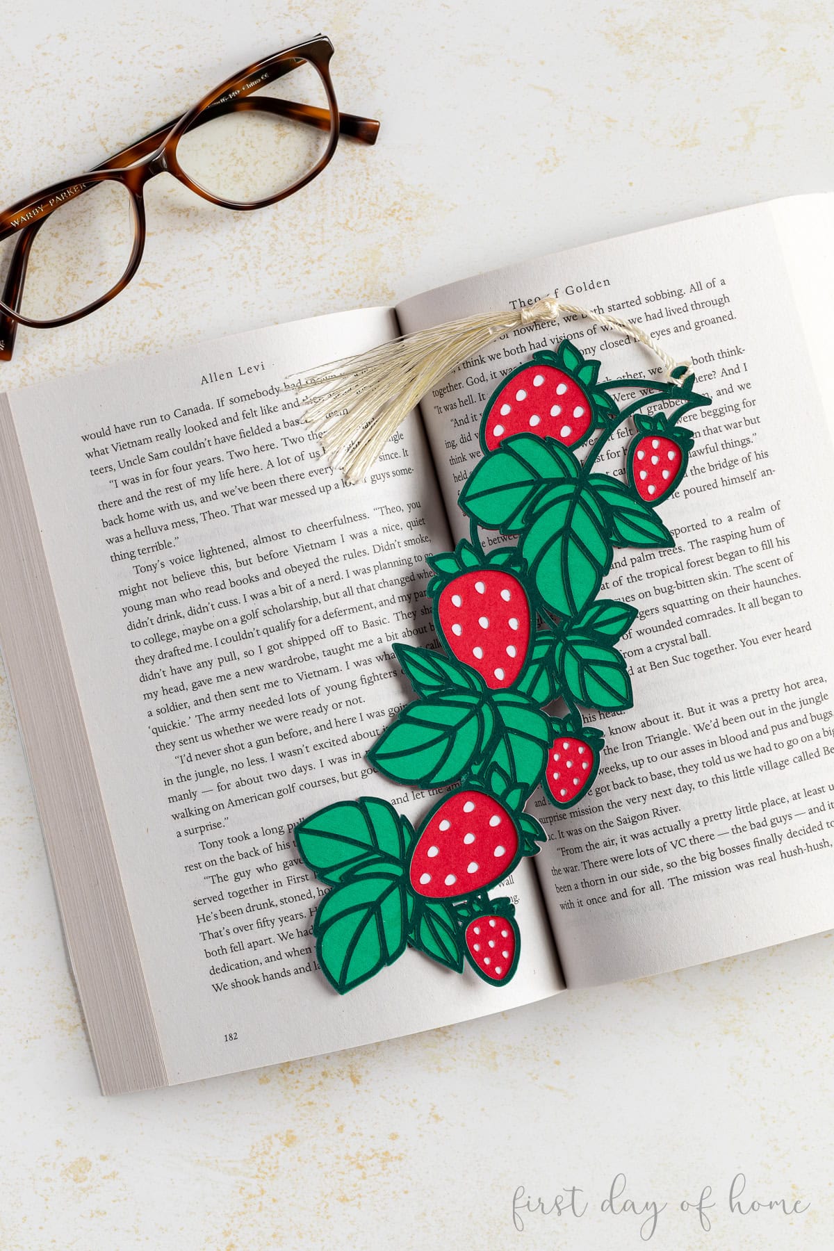 Strawberry bookmark made from cardstock sitting on a book.