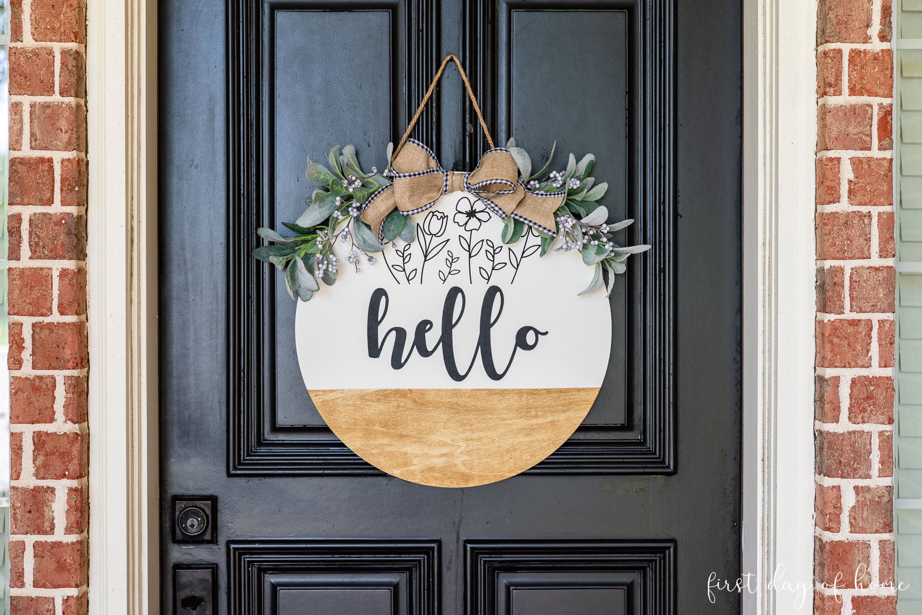 DIY wooden door hanger with the phrase "hello" hanging on a front door.